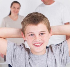 happy teen boy standing in front of parents