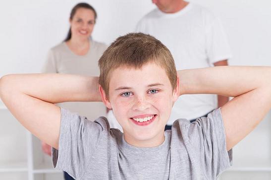 happy teen boy standing in front of parents